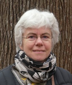 Photo of Catherine in front of a tree trunk.